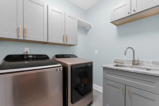 a utility room with sink dryer and washer