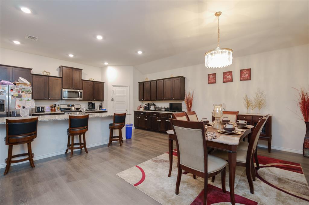 4009 Forest Bend Road Denton, TX 76208 - Photo 10 of 35 Dining room featuring dark wood finished floors, a chandelier, and lofted ceiling