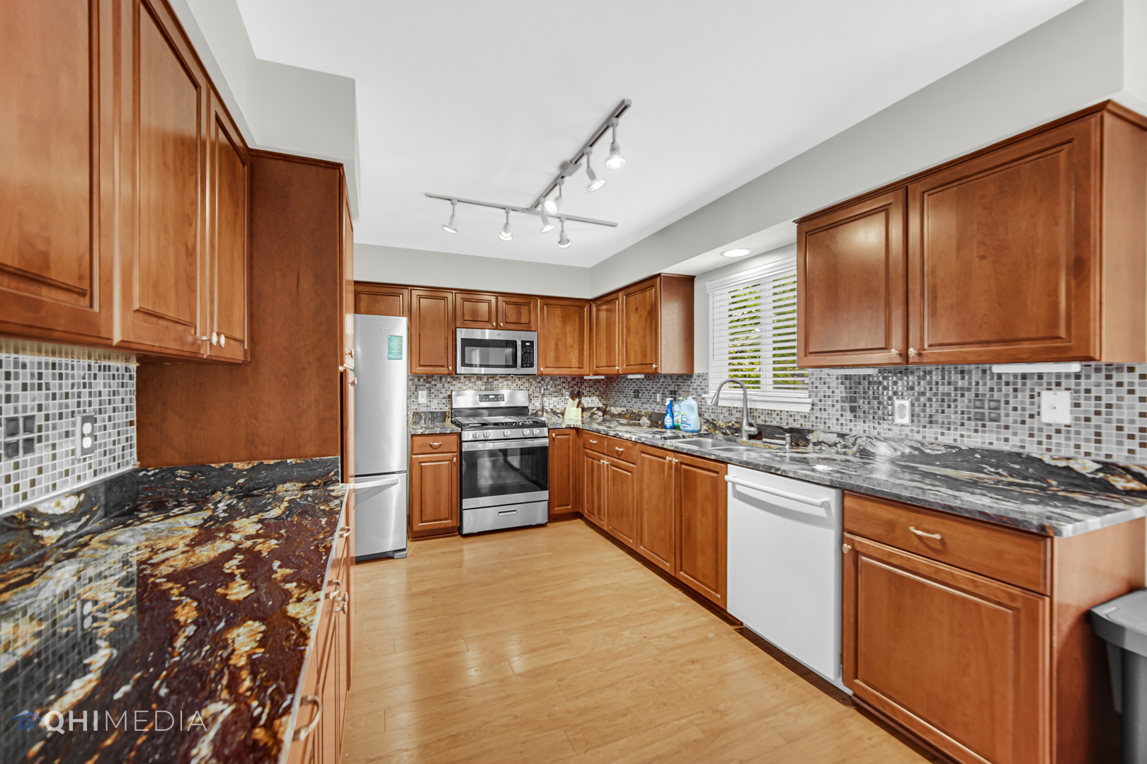 21432 Georgetown Drive Plainfield, IL 60544 - Photo 4 of 24 a kitchen with stainless steel appliances granite countertop a stove sink refrigerator and cabinets