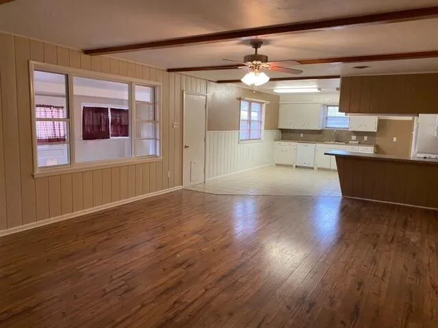 a view of a kitchen with wooden floor and a window