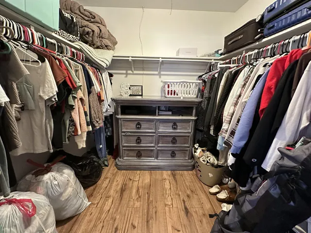 a view of walk in closet with clothes and shoes
