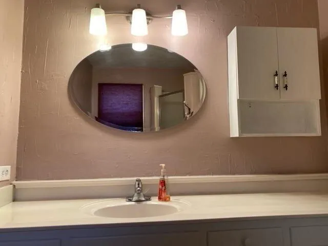 a bathroom with a granite countertop toilet sink and mirror