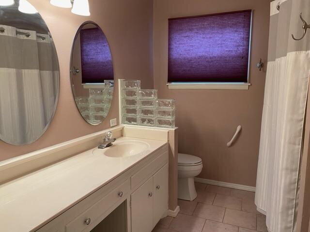 3011 55th Street Lubbock, TX 79413 - Photo 18 of 25 a bathroom with a granite countertop toilet sink and mirror