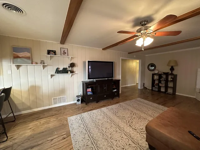 a bedroom with furniture and a flat screen tv