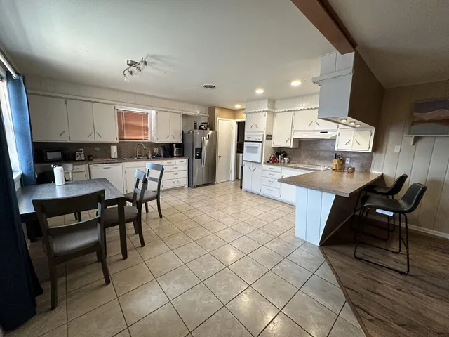 a kitchen with stainless steel appliances kitchen island granite countertop a sink and cabinets
