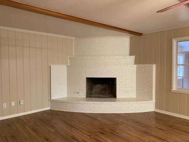 a view of a livingroom with wooden floor and a fireplace