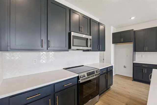 a kitchen with stainless steel appliances granite countertop a stove a microwave and a sink