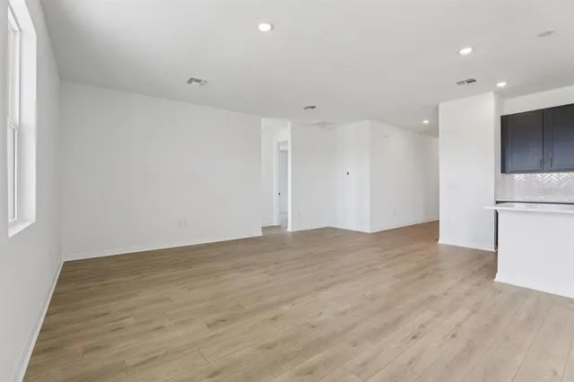 a view of empty room with wooden floor and window