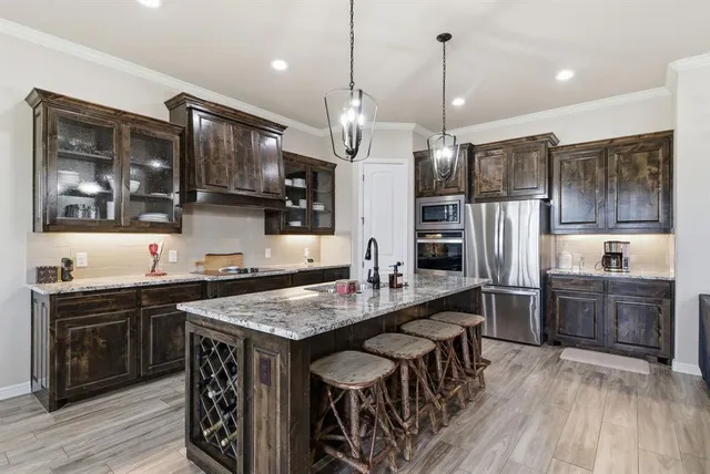 a kitchen with granite countertop a sink a counter space appliances and cabinets