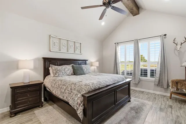 a bedroom with a bed and a dresser next to a window