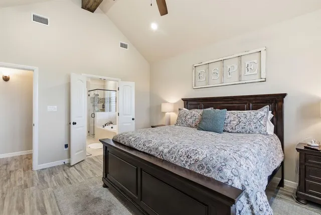 a bedroom with a bed and painting on the wall