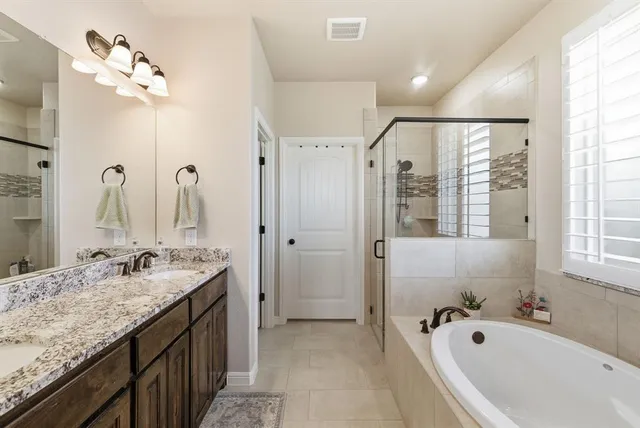 a spacious bathroom with a granite countertop tub sink and mirror