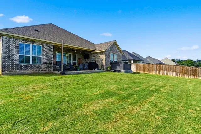 a front view of a house with a yard and trees