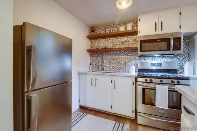 a kitchen with stainless steel appliances granite countertop a refrigerator stove and microwave