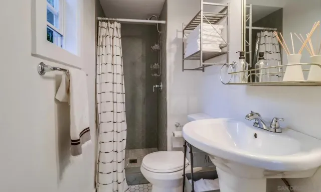 a bathroom with a sink a toilet and shower