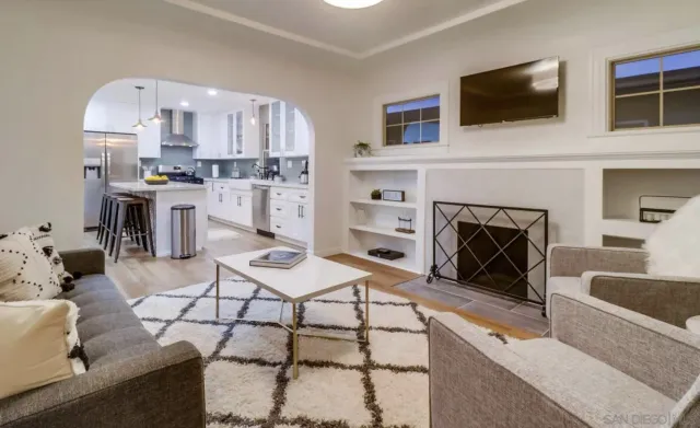 a living room with furniture a flat screen tv and a fireplace