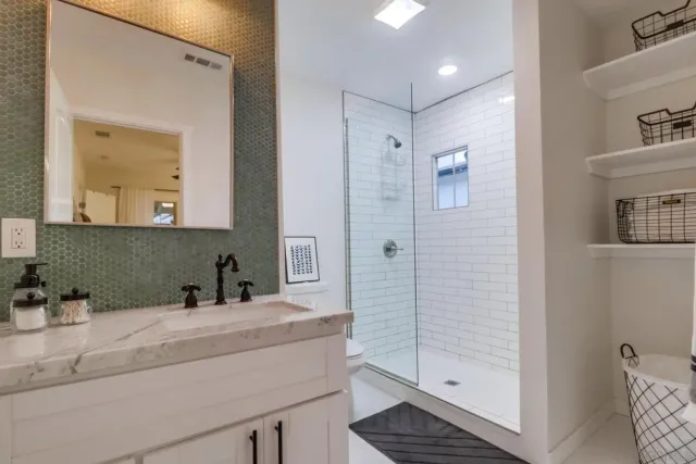a bathroom with a shower sink and mirror