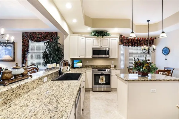 a kitchen with stainless steel appliances kitchen island granite countertop a stove a sink and a microwave