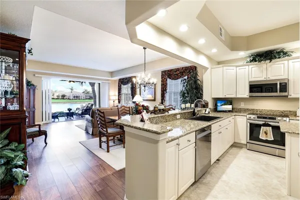 a large white kitchen with lots of counter space a sink and appliances
