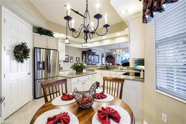 a view of a dining room and kitchen with furniture a chandelier