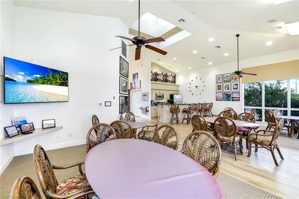 a room with lots of white furniture and a chandelier