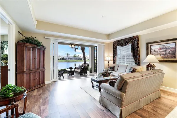 a living room with furniture large window and wooden floor