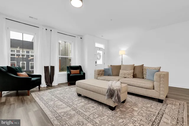 a kitchen with stainless steel appliances granite countertop a refrigerator a sink dishwasher a stove and white cabinets with wooden floor