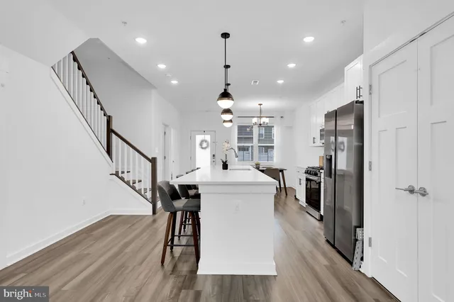 a large kitchen with stainless steel appliances lots of counter space and wooden floor