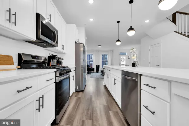 an open kitchen with kitchen island white cabinets and refrigerator