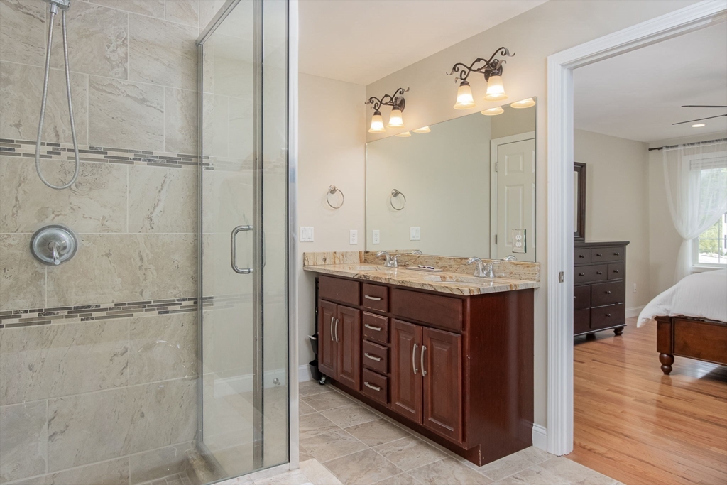78 Tavern Road Groton, MA 01450 - Photo 20 of 41 a bathroom with a granite countertop sink a mirror and shower