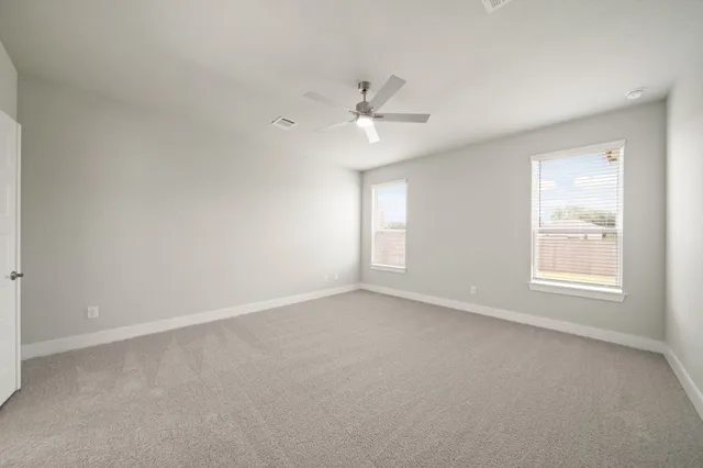 an empty room with a window and a fan