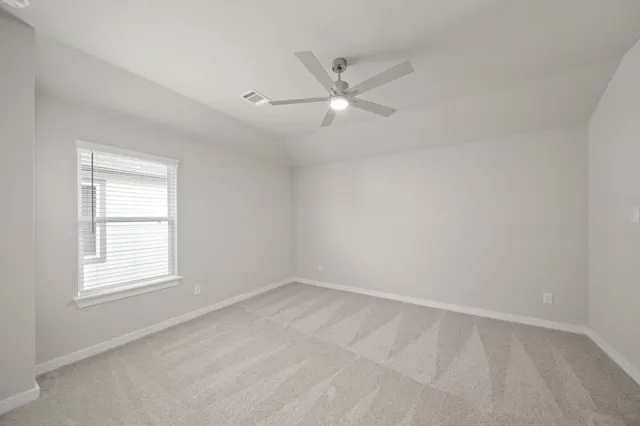 an empty room with a window and ceiling fan