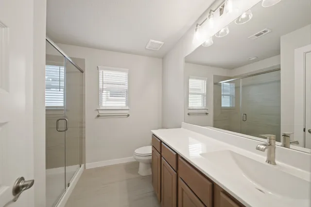 a bathroom with a double vanity sink mirror and toilet