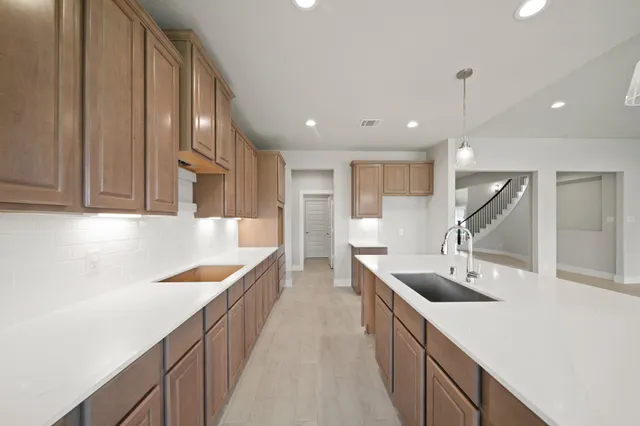 a kitchen with a sink a counter top space stainless steel appliances and cabinets