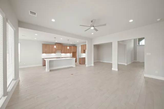 a view of an empty room with a kitchen