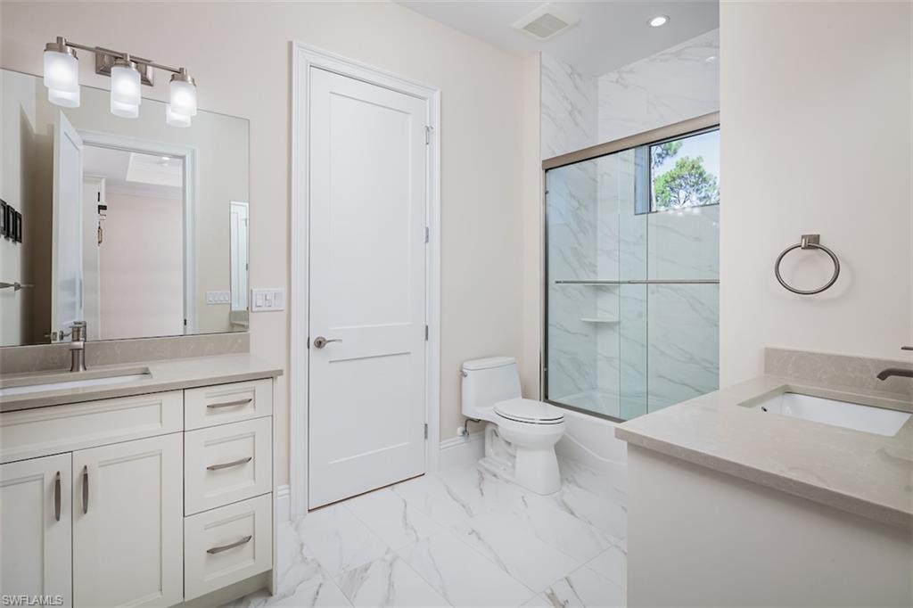 2879 Coco Lakes Drive Naples, FL 34105 - Photo 25 of 30 a bathroom with a sink a toilet and shower