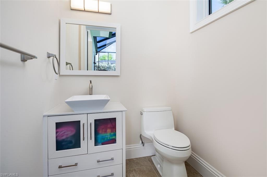 2879 Coco Lakes Drive Naples, FL 34105 - Photo 27 of 30 a bathroom with a toilet a sink and mirror