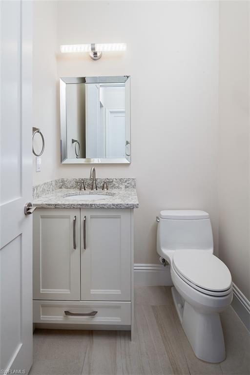 2879 Coco Lakes Drive Naples, FL 34105 - Photo 28 of 30 a bathroom with a granite countertop toilet and a sink