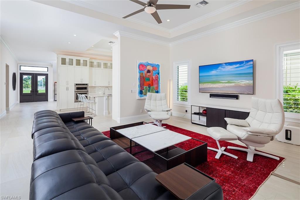 2879 Coco Lakes Drive Naples, FL 34105 - Photo 4 of 30 a living room with furniture a rug and a flat screen tv