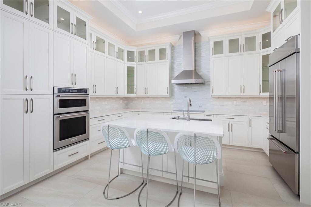 2879 Coco Lakes Drive Naples, FL 34105 - Photo 5 of 30 a kitchen with stainless steel appliances a stove a sink and cabinets