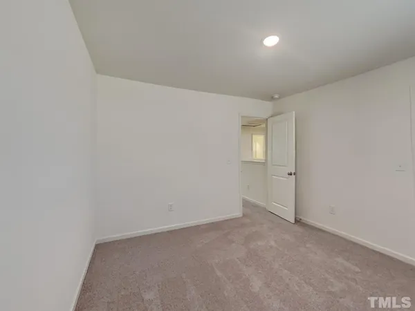 a view of an empty room with closet and a window