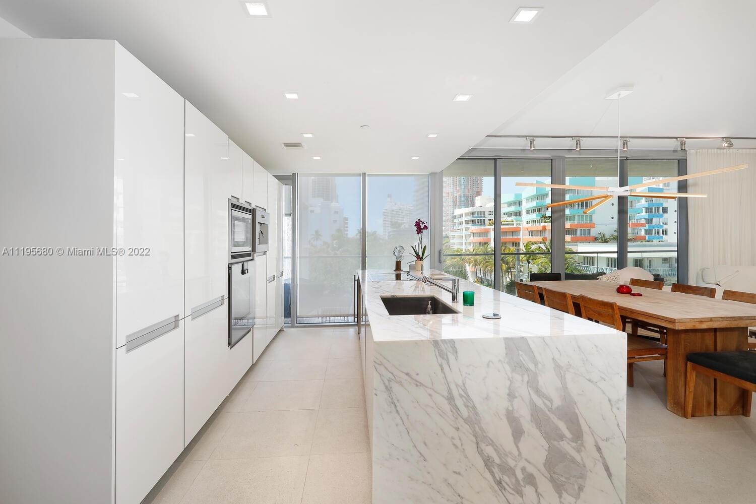 Miami Beach Miami Beach, FL 33139 - Photo 15 of 27 a living room with furniture a flat tv screen and a large window