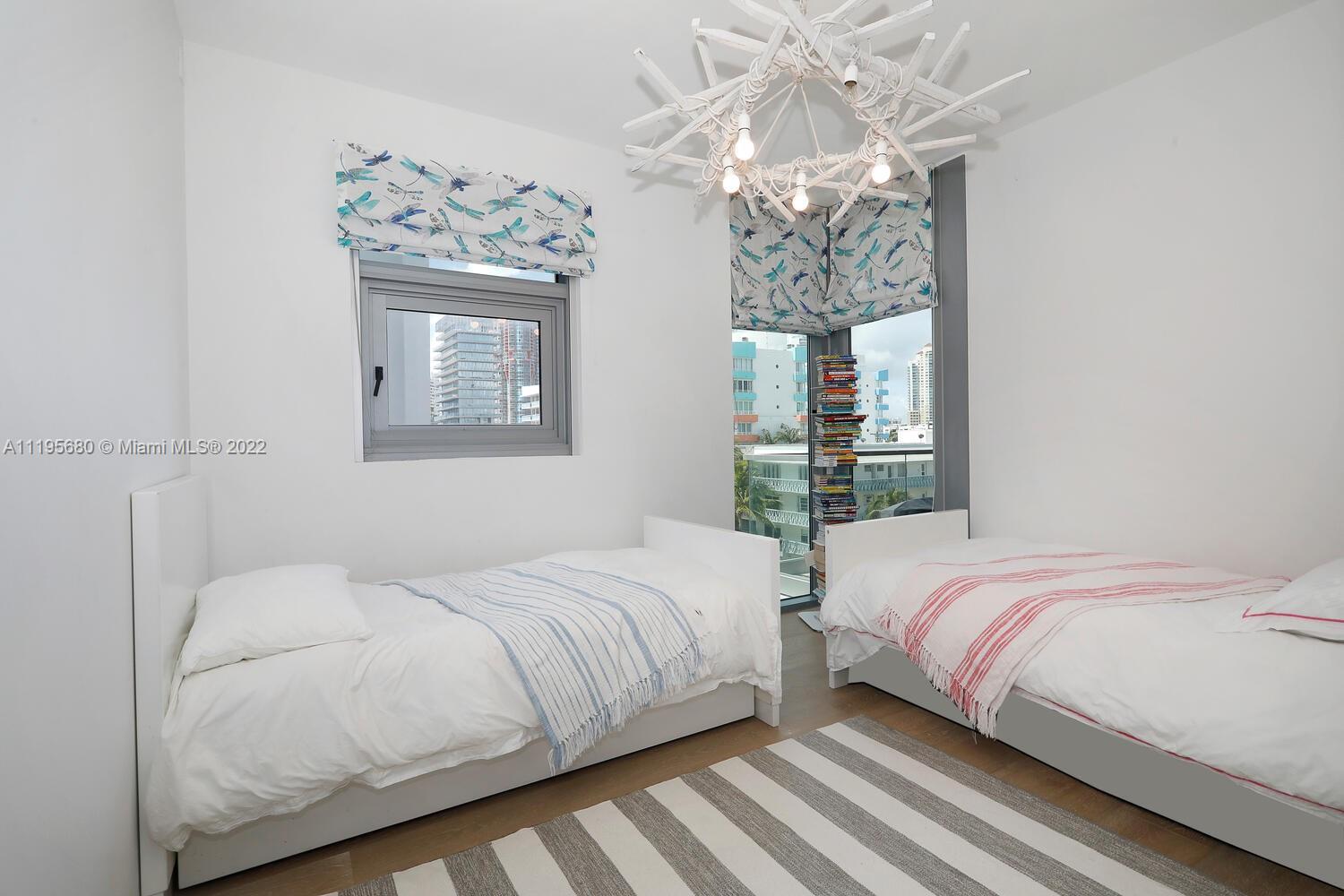 Miami Beach Miami Beach, FL 33139 - Photo 20 of 27 a bedroom with a large bed and a chandelier