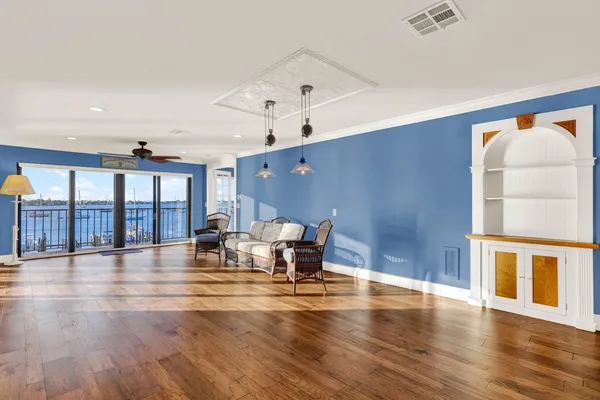 a view of a livingroom with wooden floor and a ceiling fan