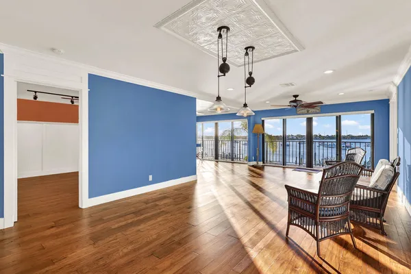 a view of a livingroom with wooden floor and a ceiling fan