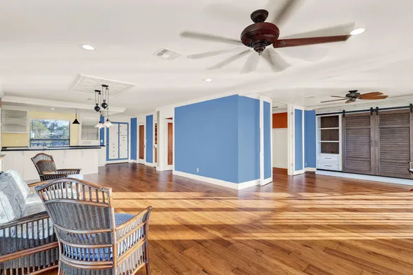 a view of a room with wooden floor and a ceiling fan
