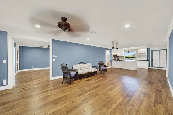 a kitchen with granite countertop a stove a sink dishwasher and a flat screen tv