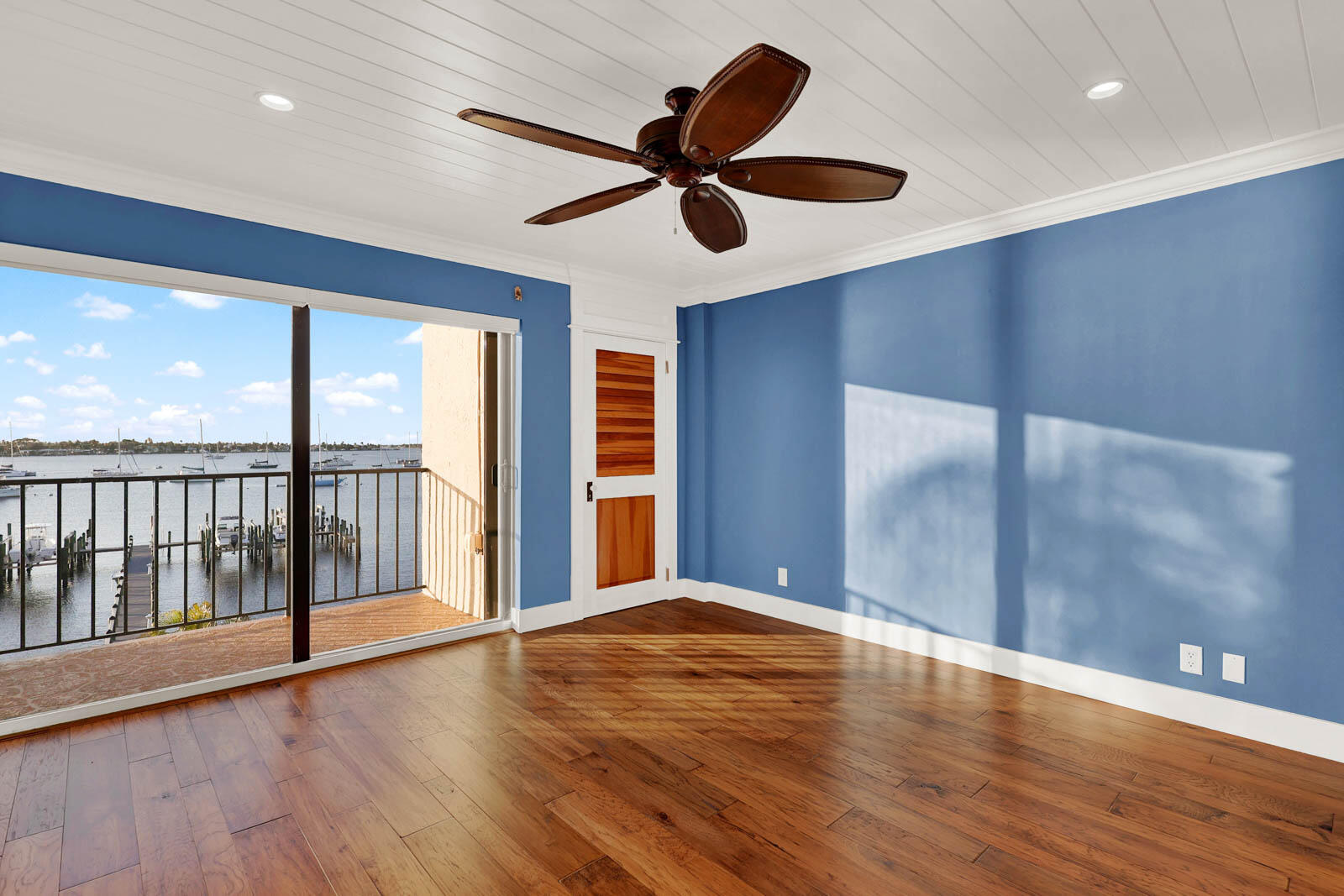 624 Southwest St Lucie Crescent, Unit 306 Stuart, FL 34994 - Photo 30 of 49 a view of an empty room with wooden floor and a ceiling fan