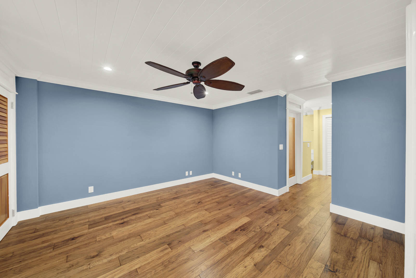 624 Southwest St Lucie Crescent, Unit 306 Stuart, FL 34994 - Photo 6 of 49 an empty room with wooden floor and a ceiling fan