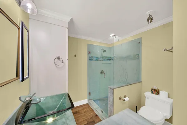 a bathroom with a granite countertop sink a mirror and shower